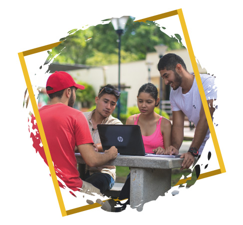 Imagen de estudiantes frente a un portátil en las mesas del campus de Unibagué