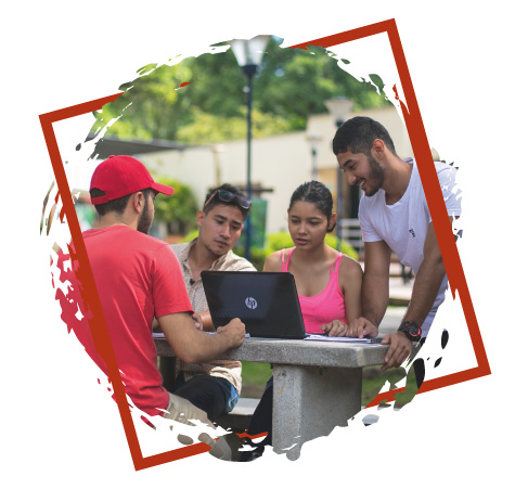 Imagen de estudiantes frente a un computador sobre una de las mesas del campus de Unibagué